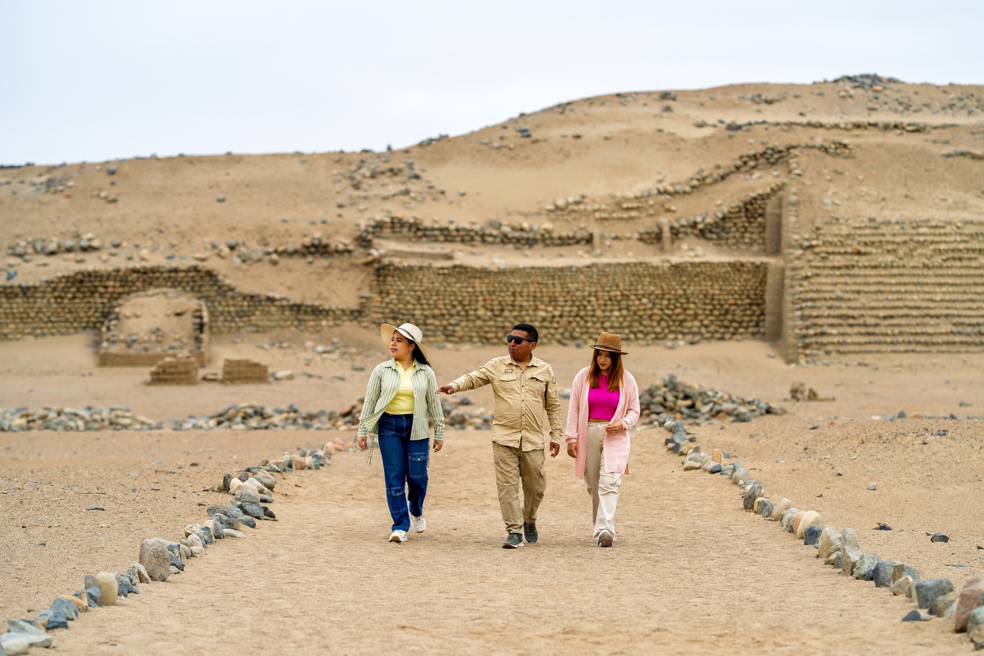 Tourists exploring pre-inca ruins with tour guide in peruvian desert